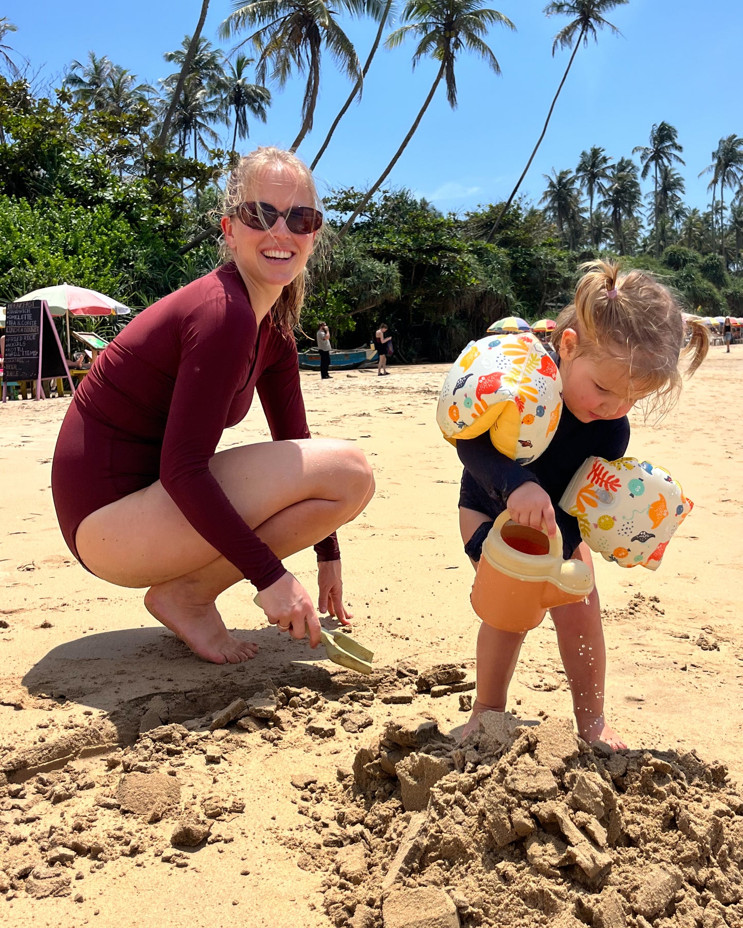 Woman and child playing on the beach.
