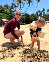 Woman and child playing on the beach.